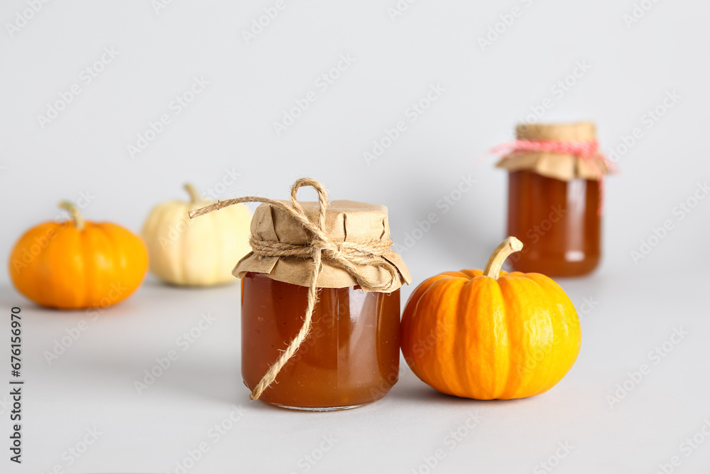 Jar of sweet pumpkin jam on white background