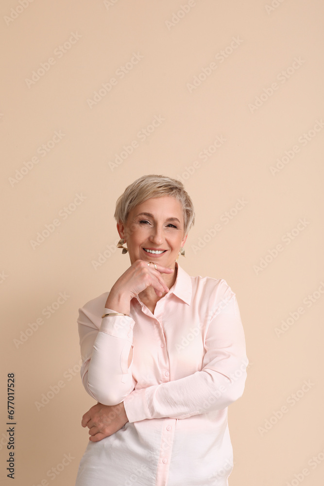 Mature blonde woman on beige background