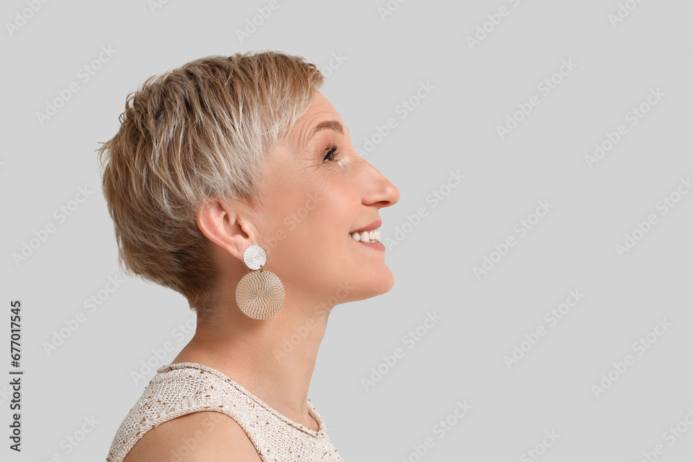 Mature blonde woman on light background, closeup