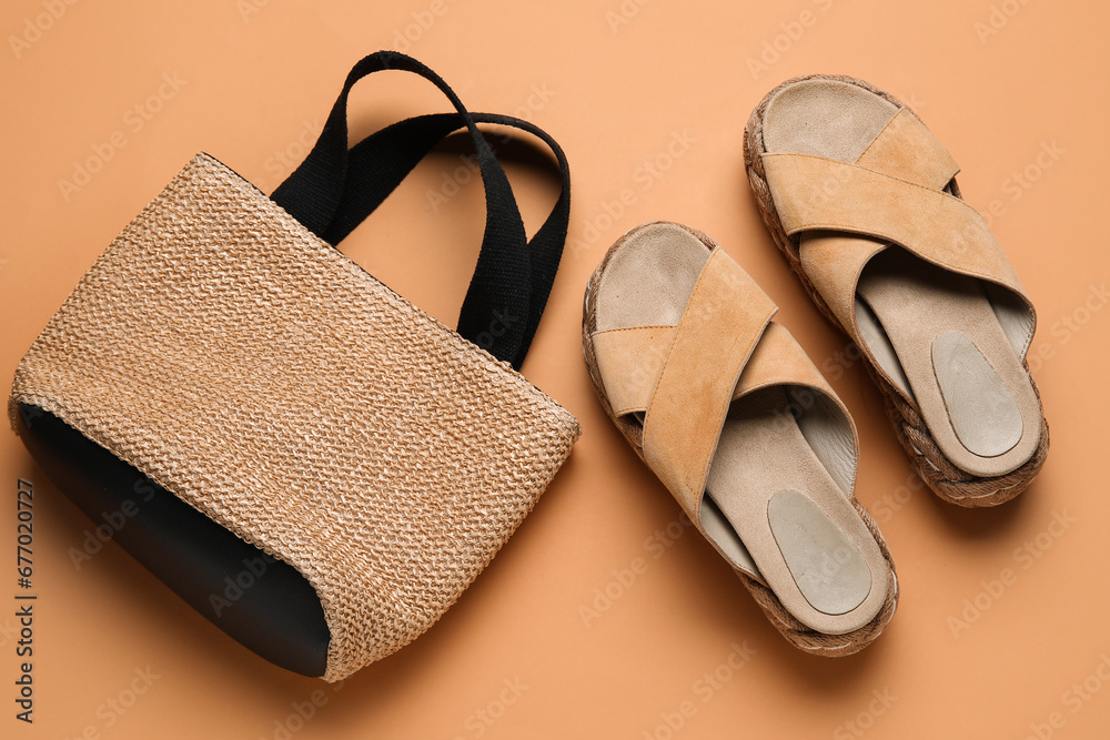 Stylish sandals and wicker bag on brown background