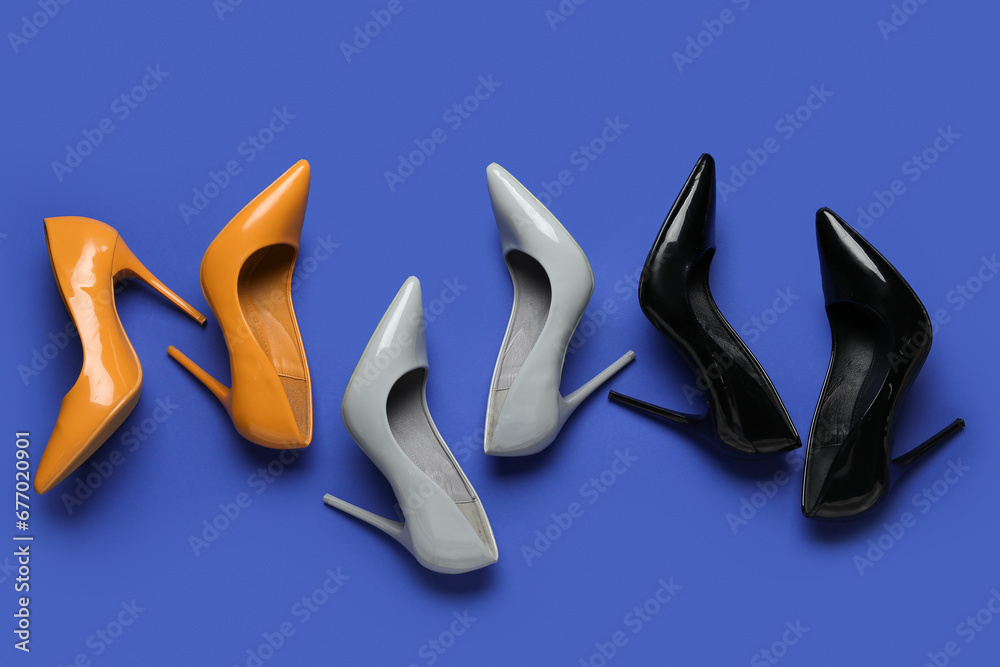 Different stylish high heels on blue background