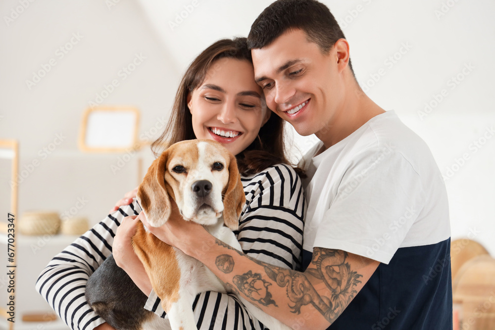 Young couple with cute Beagle dog at home, closeup