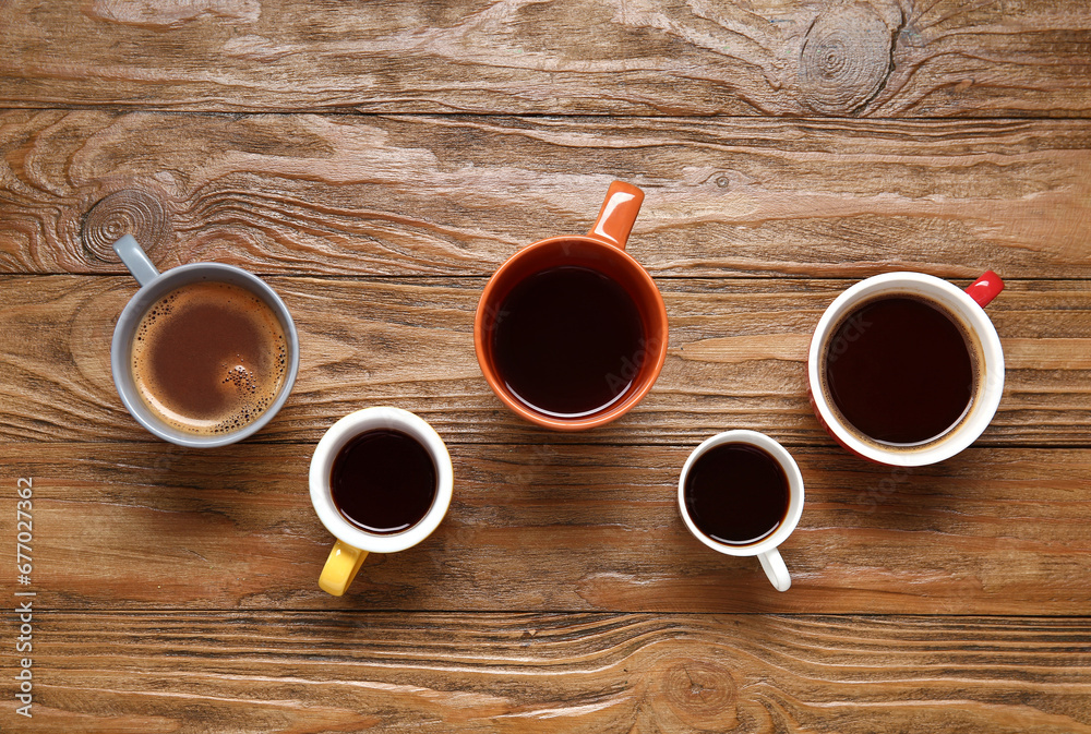 Cups of hot coffee on wooden background