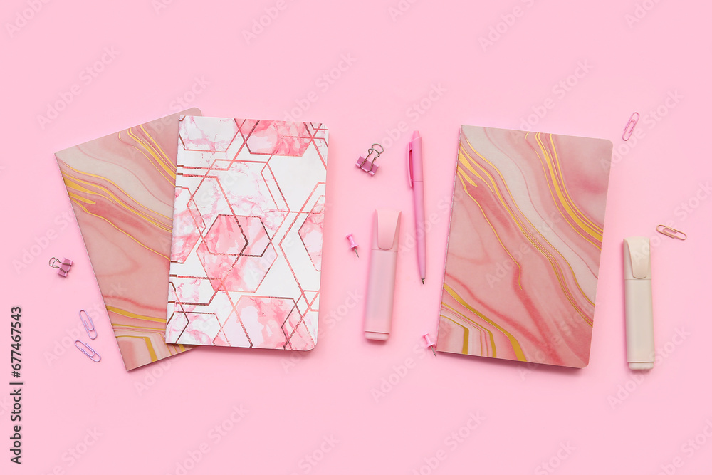 Composition with notebooks and stationery on pink background