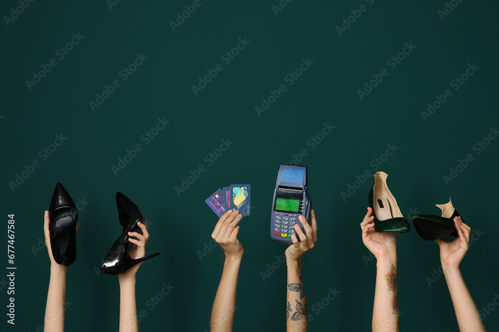 Women holding different stylish high heels, payment terminal and credit cards on green background