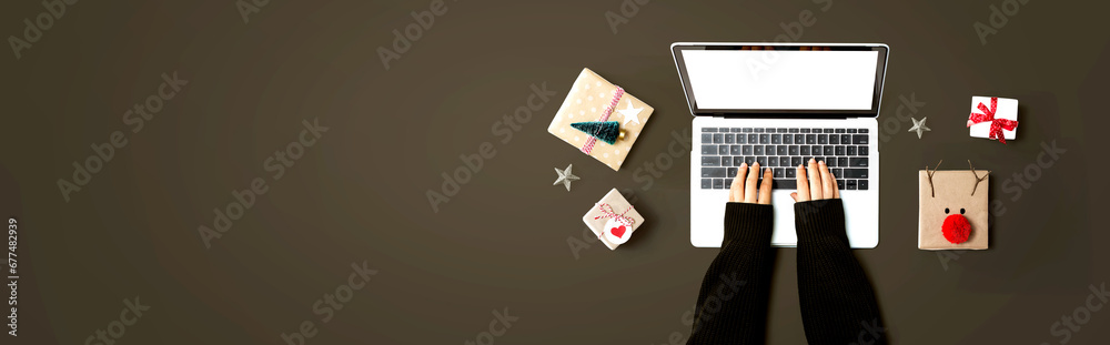 Person using a laptop computer with Christmas gift boxes from above