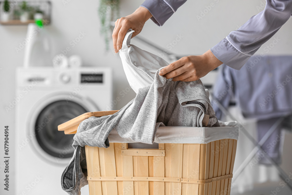 Woman with dirty clothes in laundry basket at home, closeup