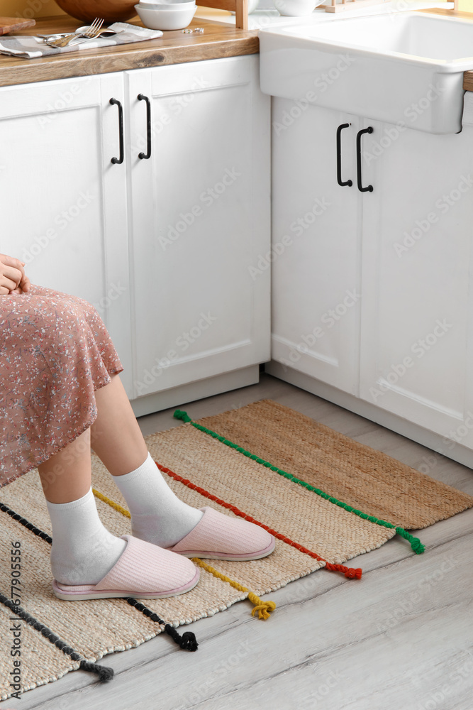 Woman sitting in chair with feet on stylish rug