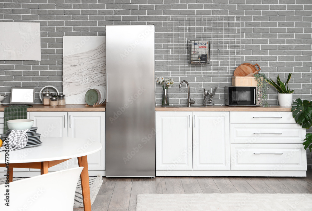 Interior of kitchen with stylish fridge, counters and table