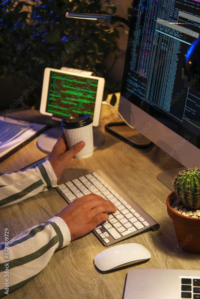 Female programmer working with computer in office at night, closeup