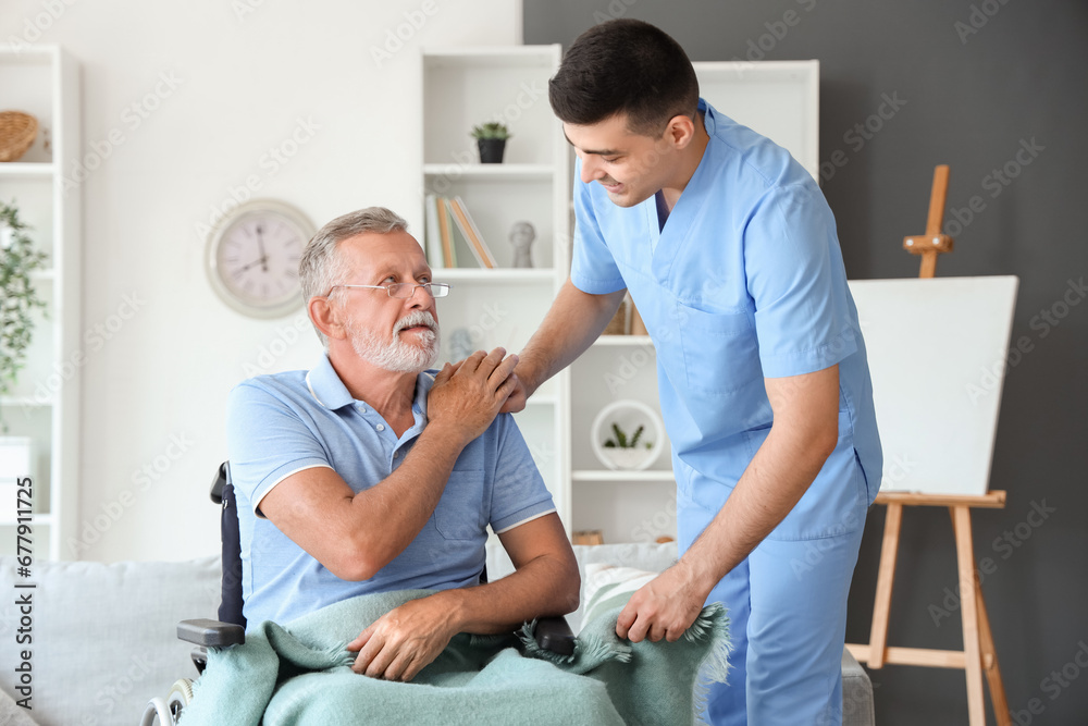 Male nurse with senior man in wheelchair at home