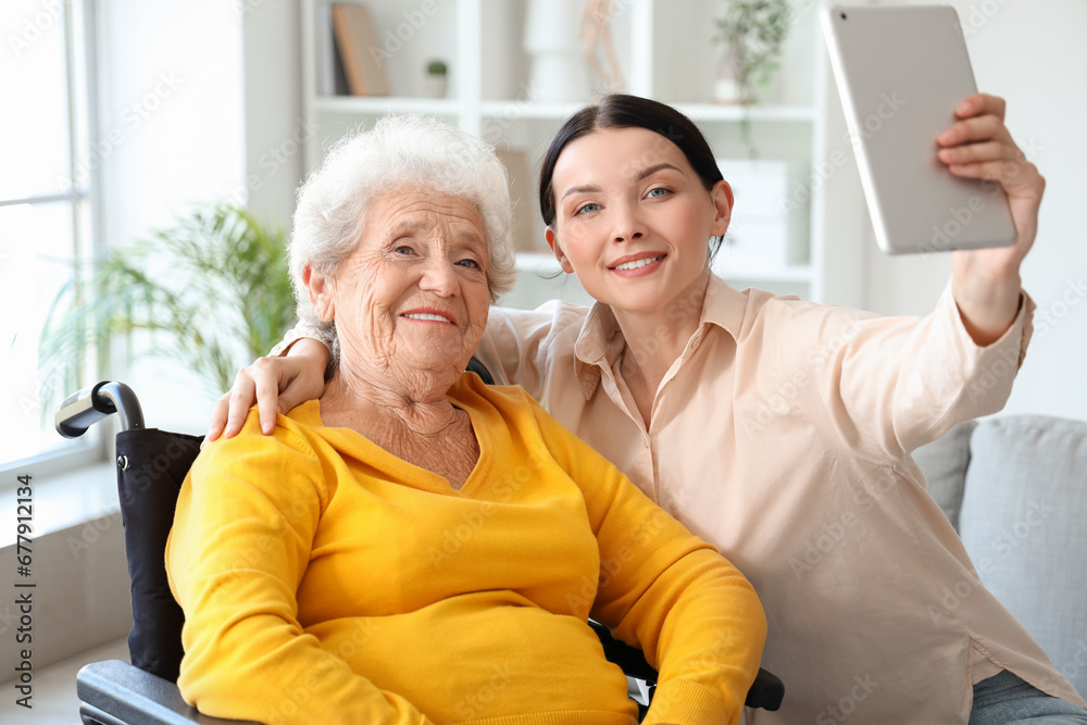 Senior woman in wheelchair with her daughter video chatting at home