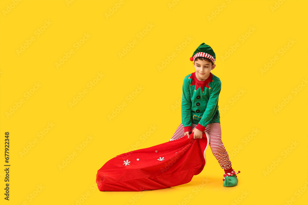 Cute little elf with bag of gifts on yellow background