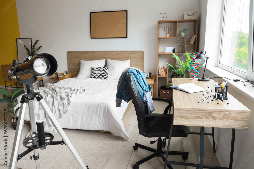 Interior of childrens bedroom with telescope, desk and cozy bed