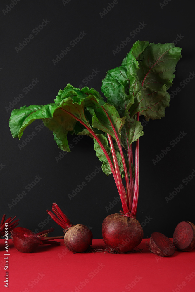 Fresh beets with green leaves on color background