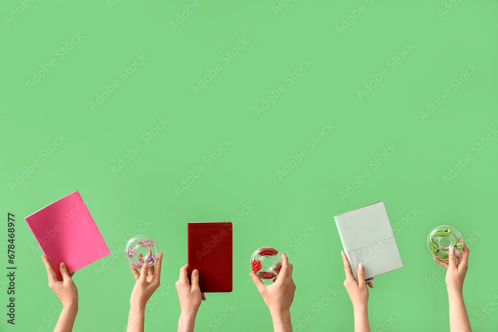 Hands holding school supplies on green background