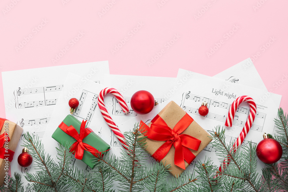 Composition with music sheets, Christmas decorations and gifts on pink background