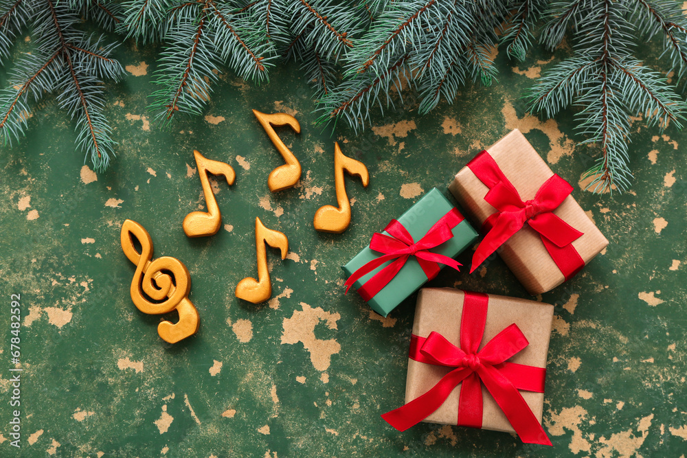 Composition with music signs, Christmas gifts and fir branches on color background