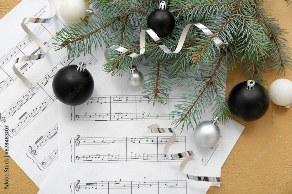 Composition with music sheets, Christmas decorations and fir branches on color background