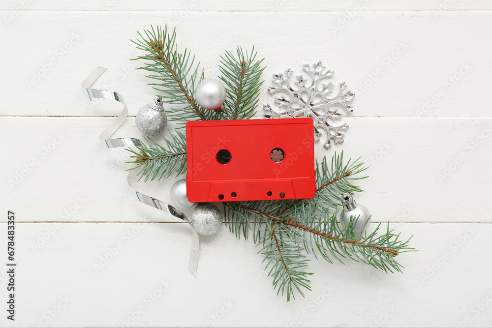 Composition with audio cassette, fir branches and Christmas decorations on light wooden background