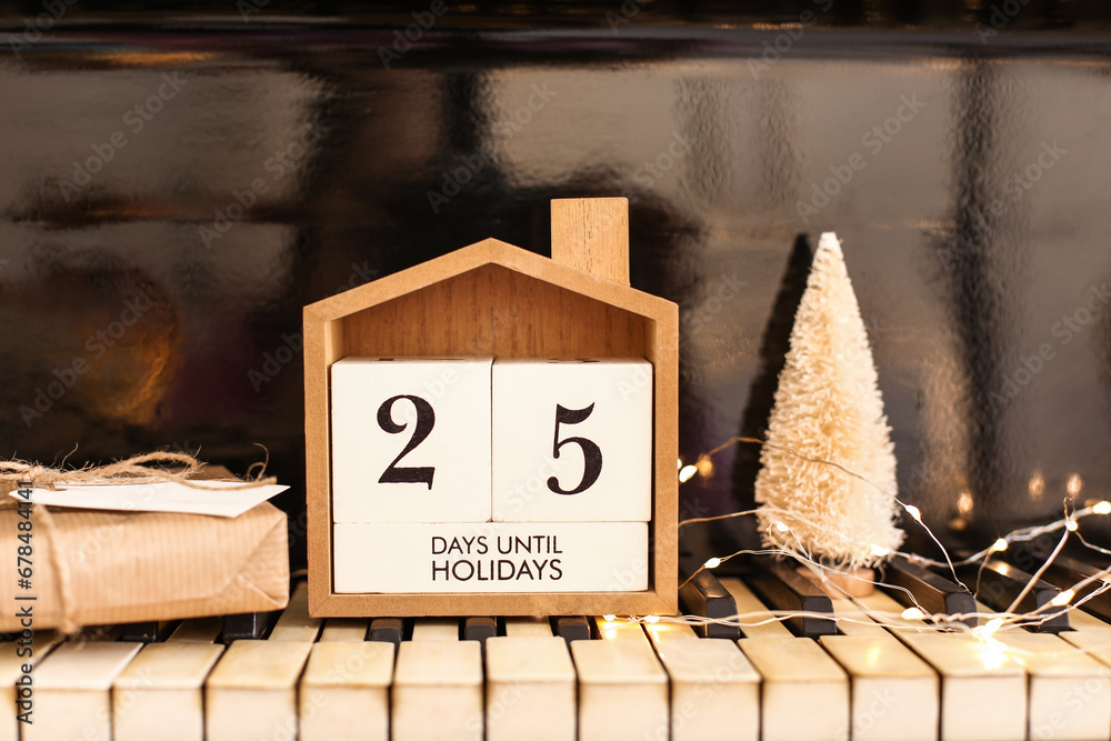 Calendar with text 25 DAYS UNTIL HOLIDAYS, Christmas decorations and gift on piano keys