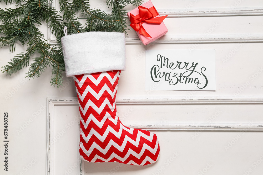 Christmas sock with greeting card and gift box on white background