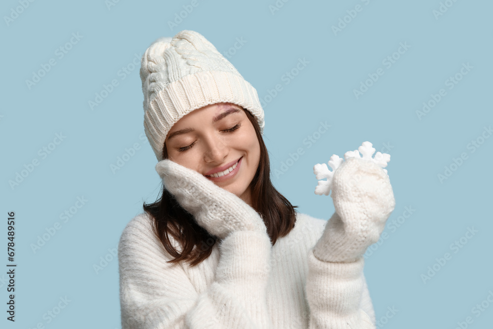 Dreaming young woman with decorative snowflakes on blue background