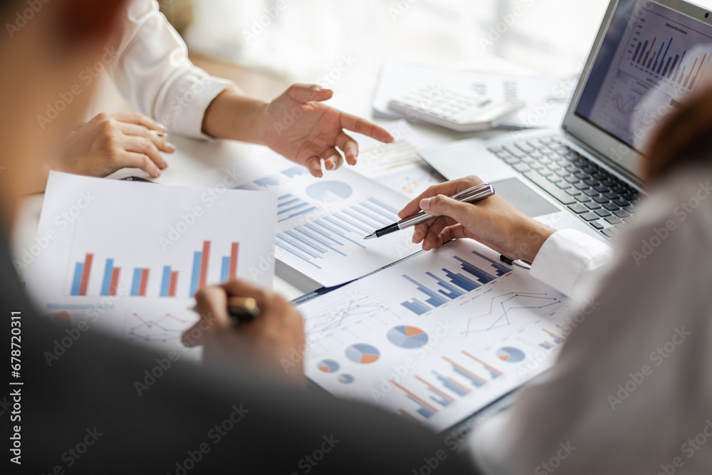 Business people and colleagues brainstorm together analyzing charts, financial reports and market growth graphs to plan new business investment strategies. Meeting to discuss statistical analysis.