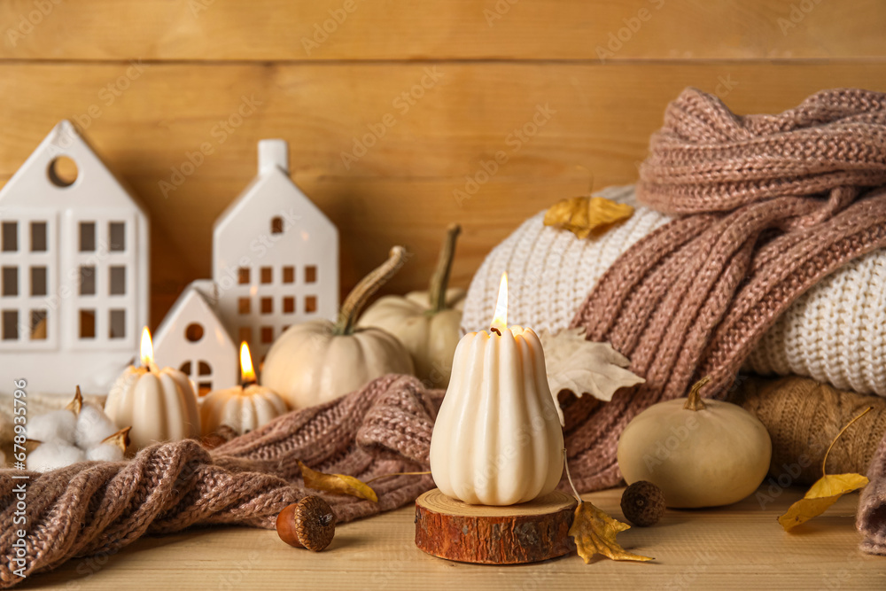 Beautiful composition with candles, pumpkins and autumn decorations on brown wooden background