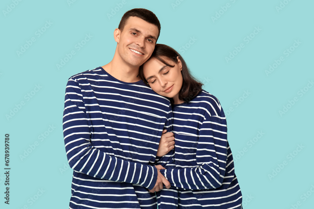 Cheerful young couple hugging on blue background