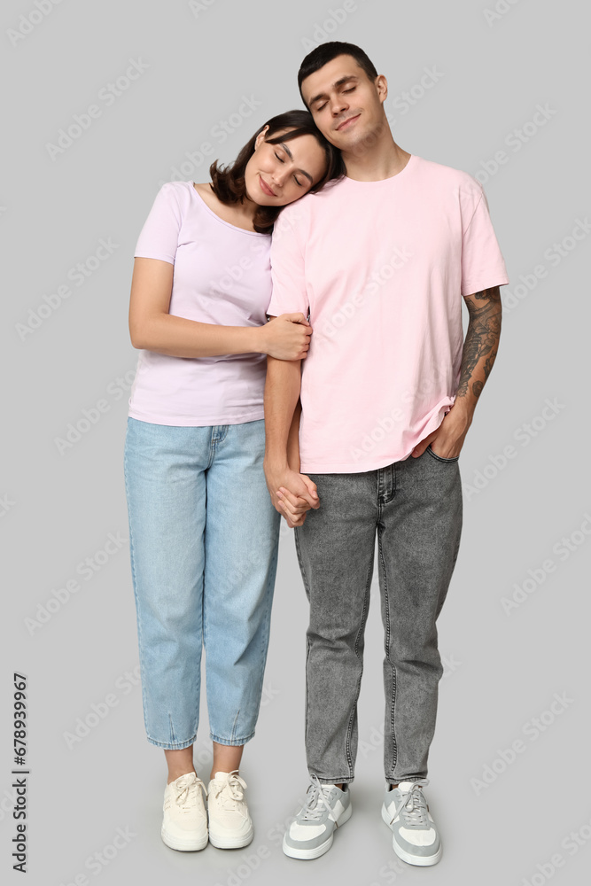 Happy young couple hugging on grey background