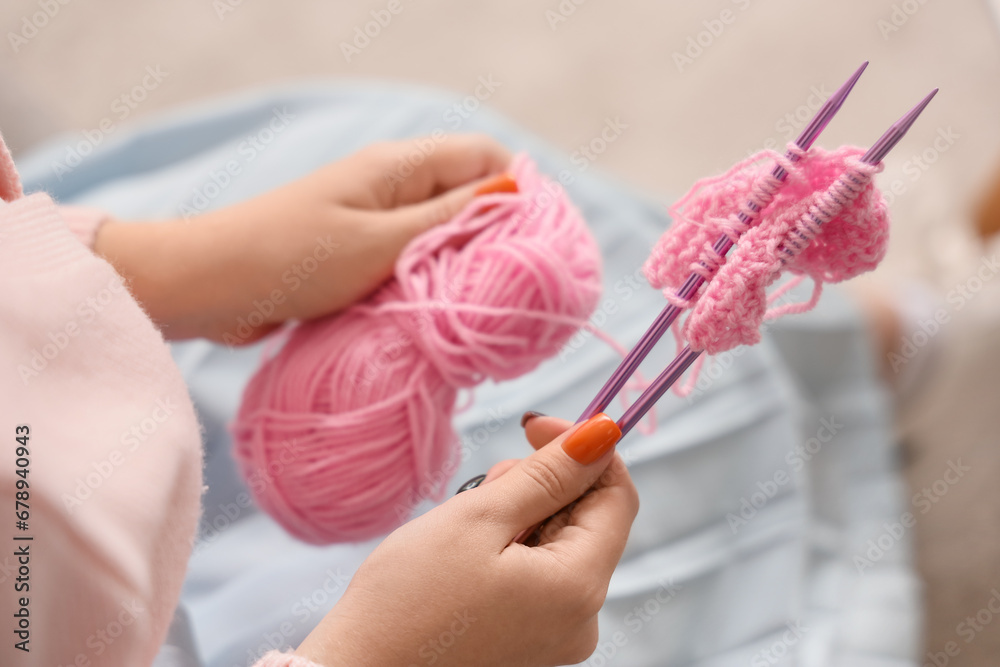 Young woman knitting with needles at home, closeup