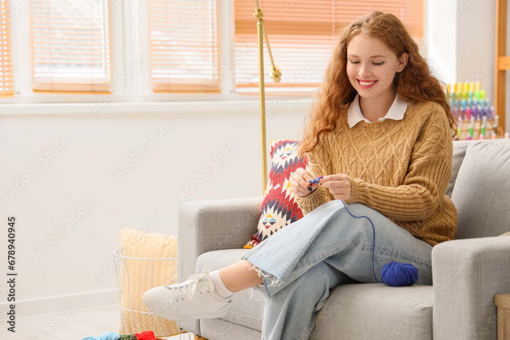 Young woman knitting with crochet at home