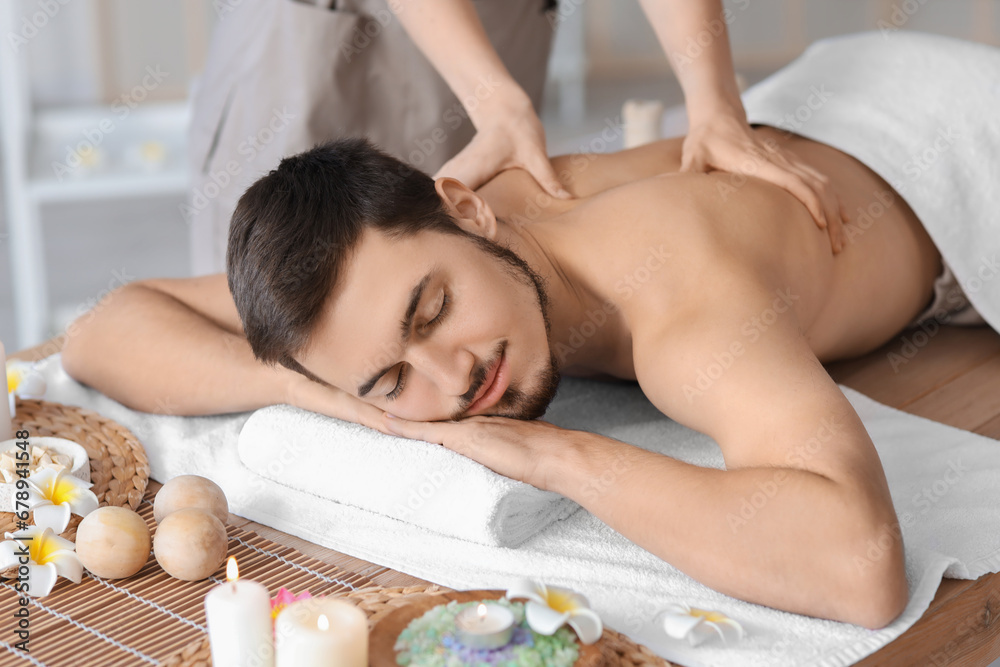 Young man getting massage in spa salon, closeup