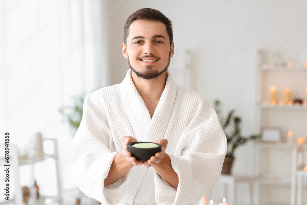 Young man with sea salt in spa salon