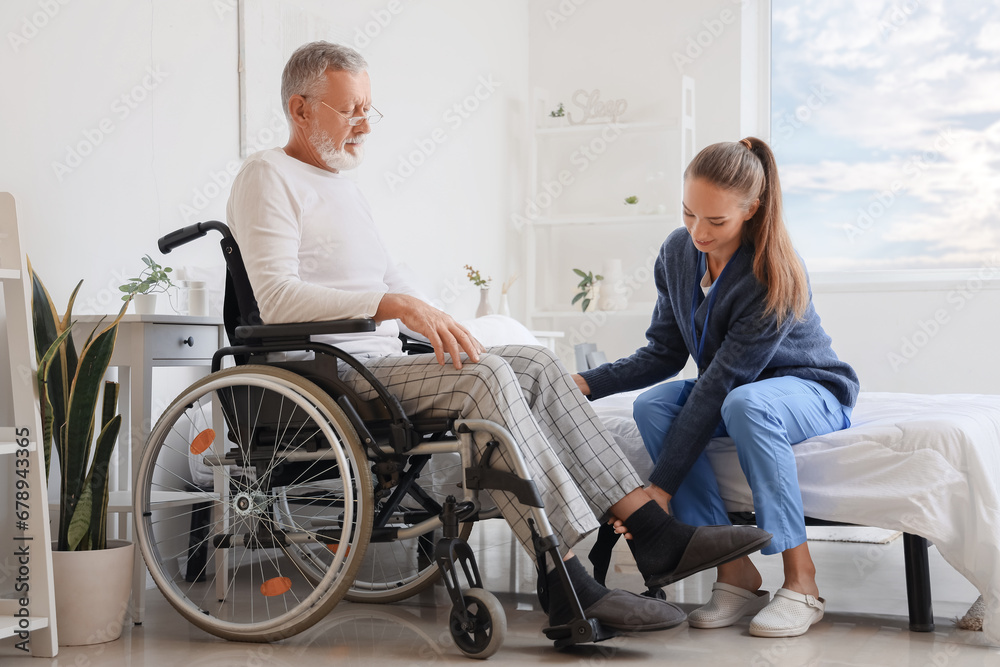 Senior man in wheelchair with caregiver at home