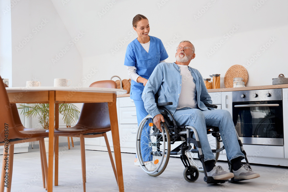 Senior man in wheelchair with nurse at home