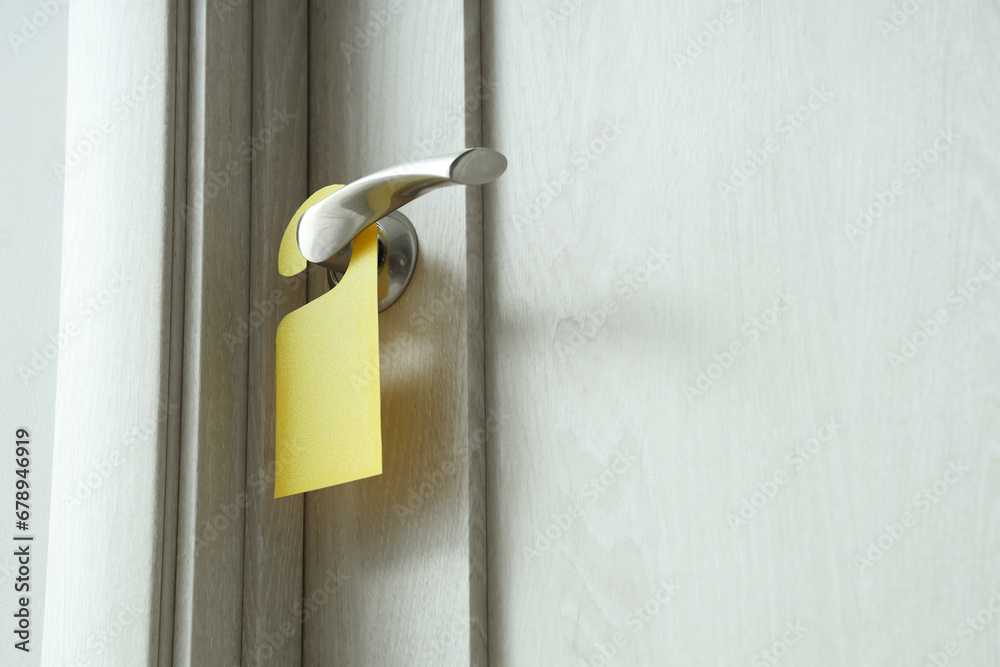 Wooden door with hanger in hotel room, closeup