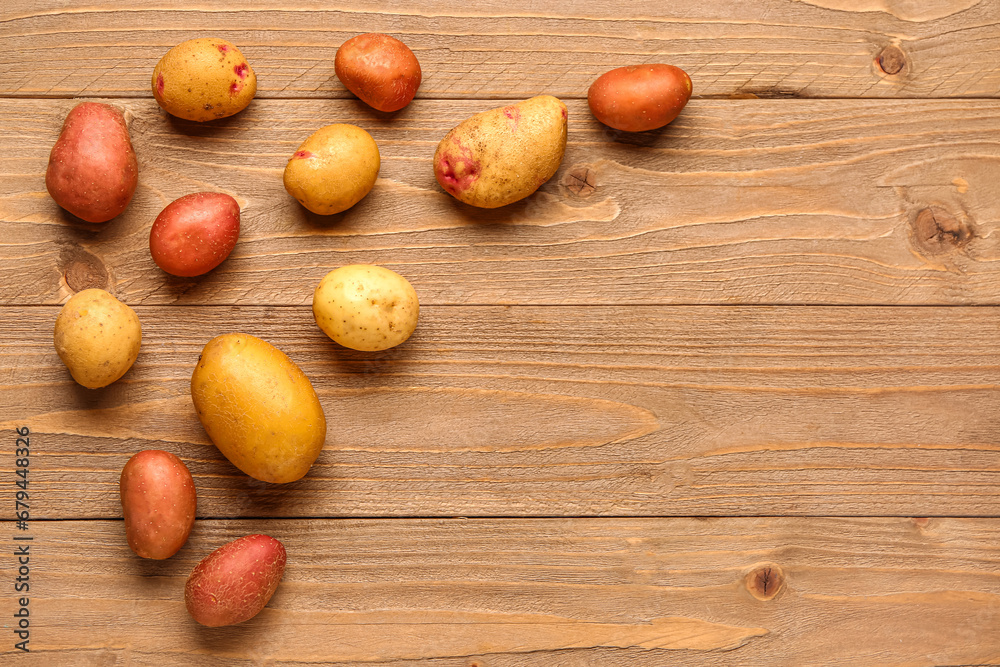 Fresh raw potatoes on wooden background