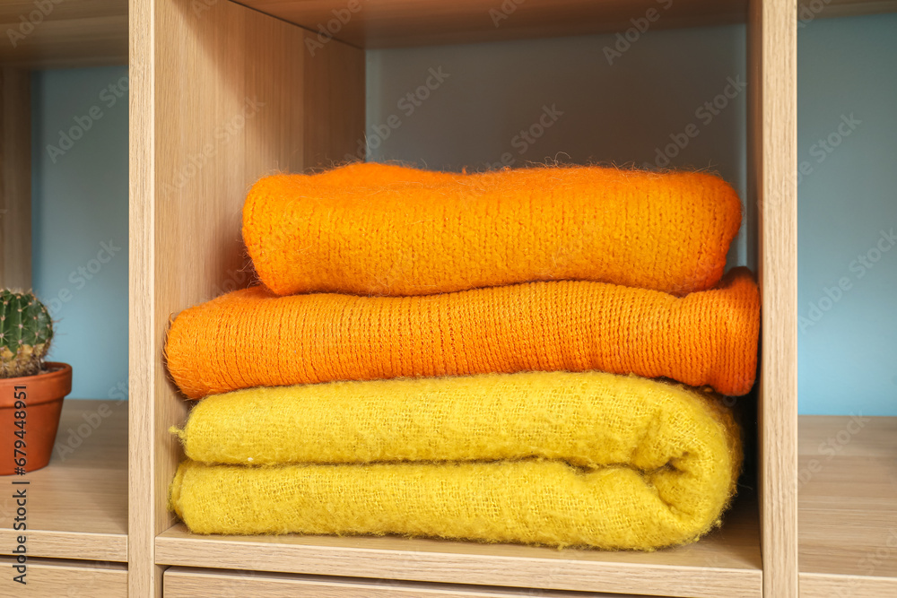 Stack of warm clothes in wardrobe, closeup