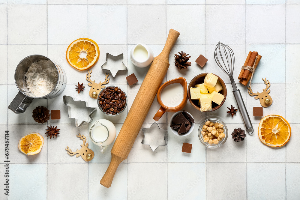 Different ingredients for preparing Christmas pie on white tile background