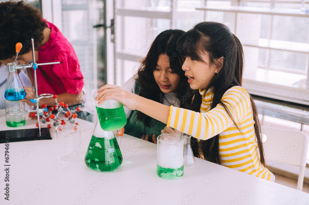 Group of women and men working together. Children in white play as scientists in a laboratory using equipment.