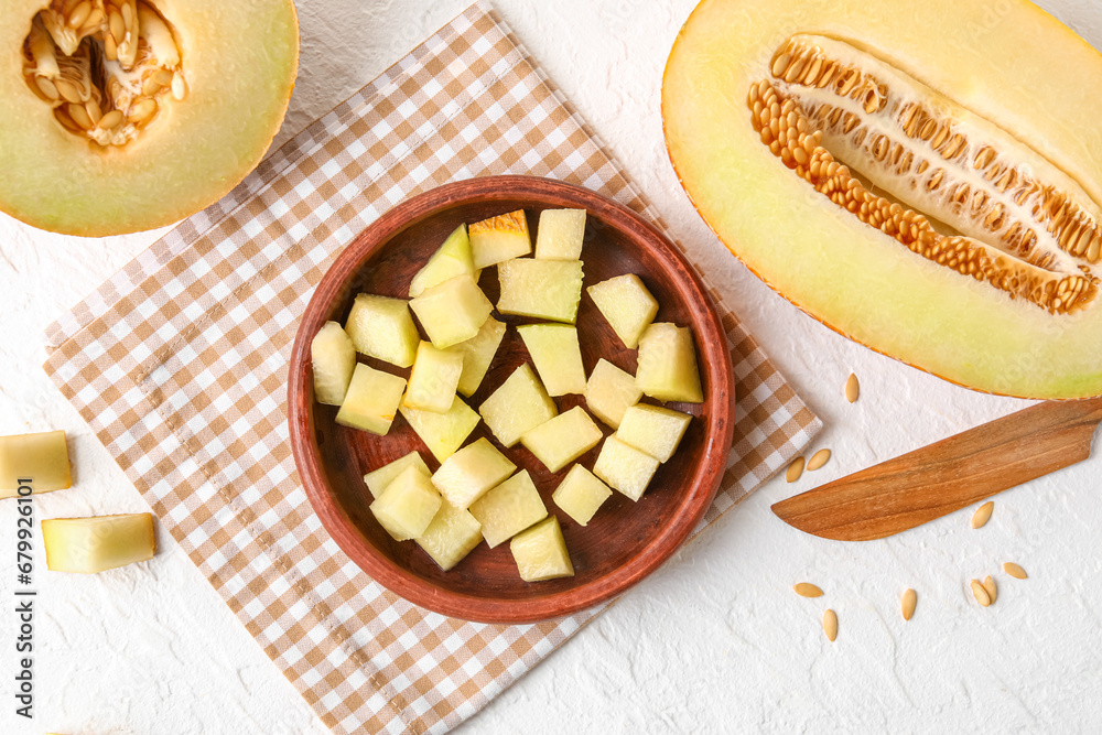 Bowl with pieces of sweet melon on white background