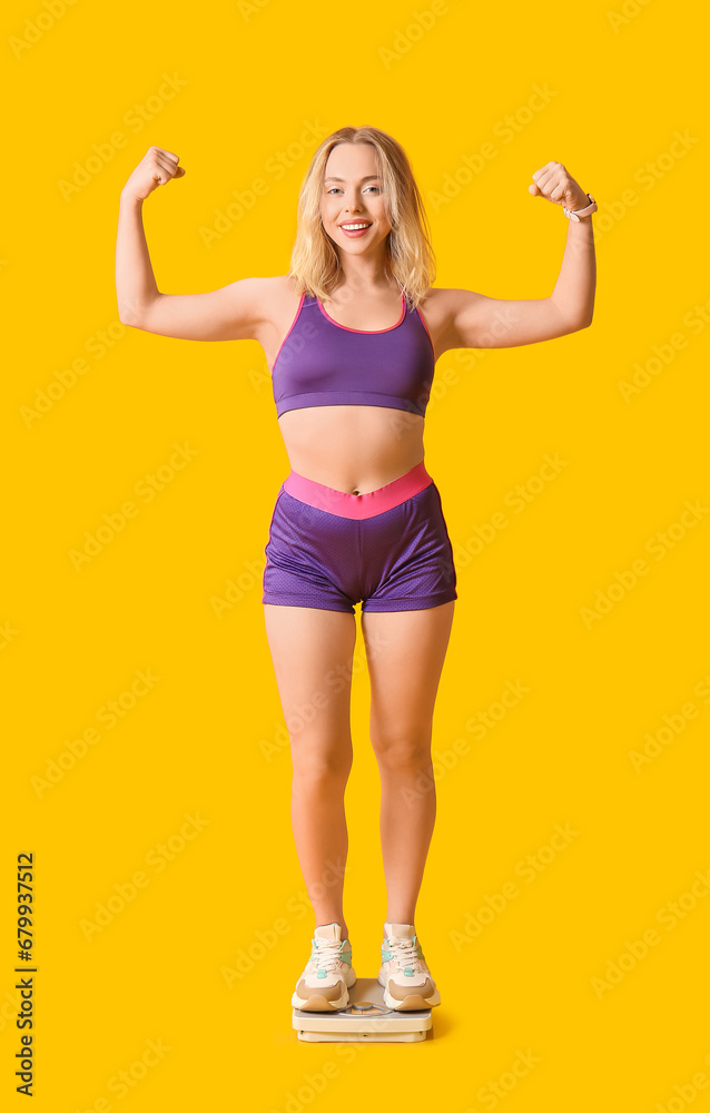 Beautiful sporty woman with scales on yellow background. Weight loss concept