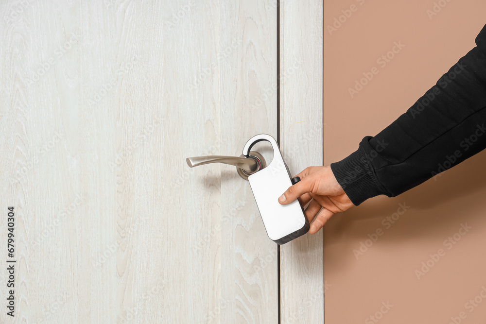 Man with door hanger in hotel room, closeup