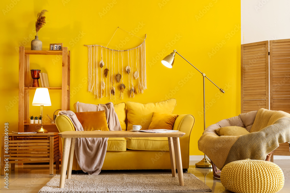 Interior of stylish living room with cozy yellow sofa and glowing lamps