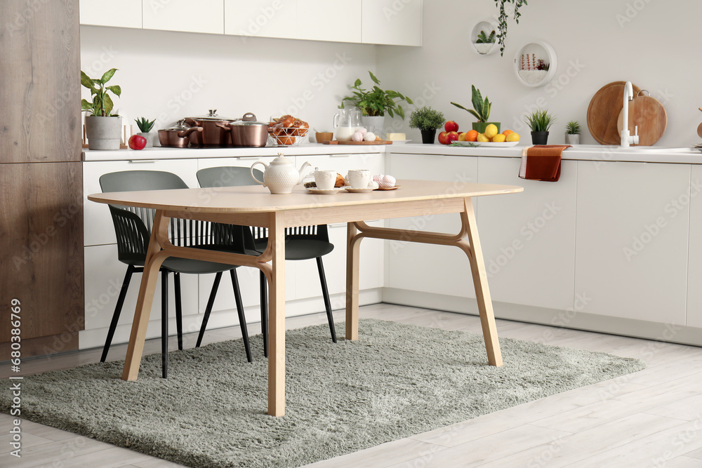 Interior of modern kitchen with wooden dining table