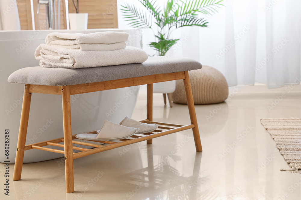 Grey bench with folded towels in bathroom, closeup