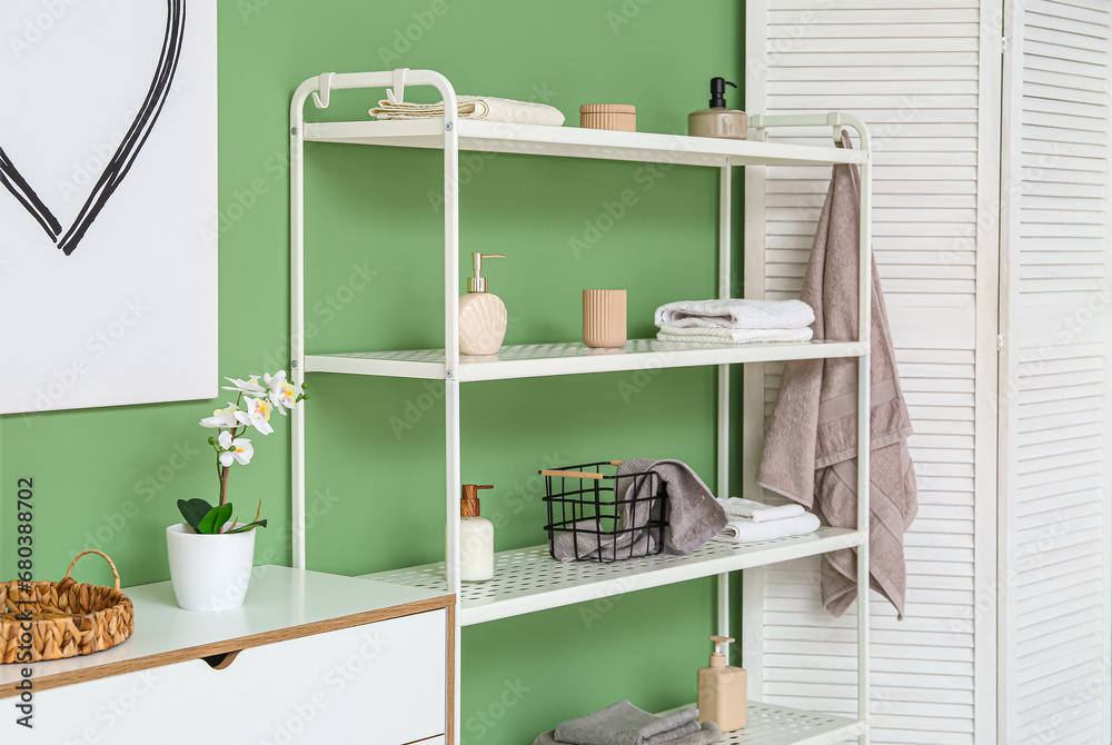 Modern shelf unit with folding screen near green wall