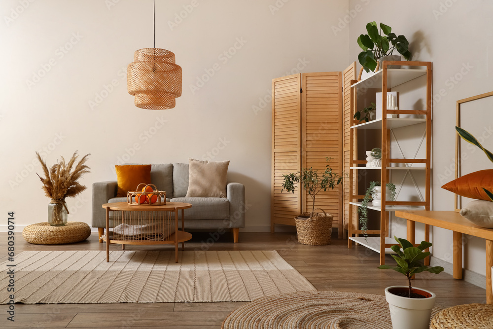 Interior of modern living room with grey sofa, coffee table and folding screen